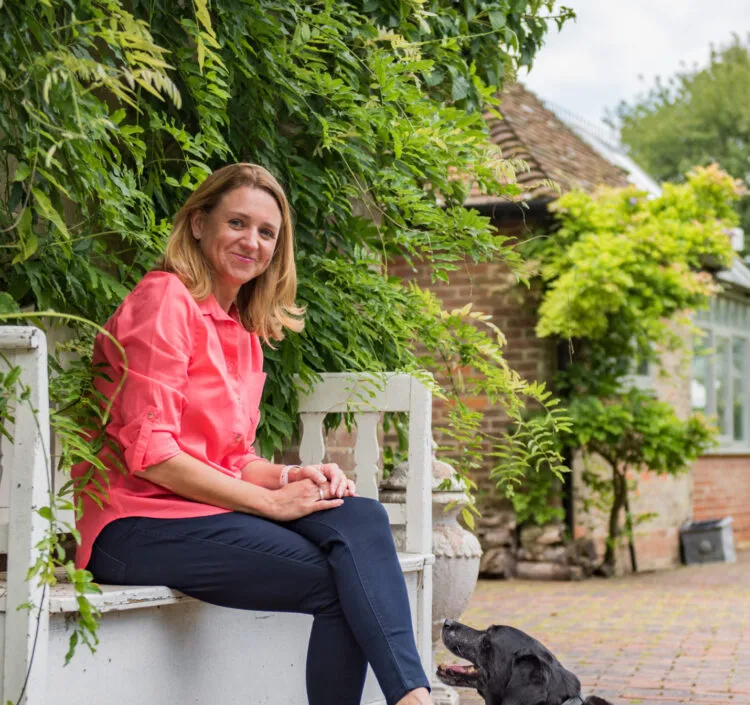 Nicky Russon, a co founder of Bloom Stays, sat on the bench at Dormestone Farm with a black Labrador by her feet.