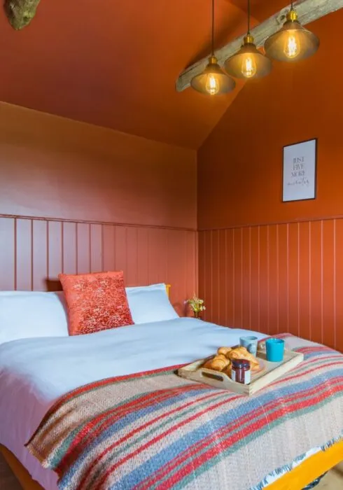 The vibrant terracotta bedroom at Challenger, McCanns Brewery