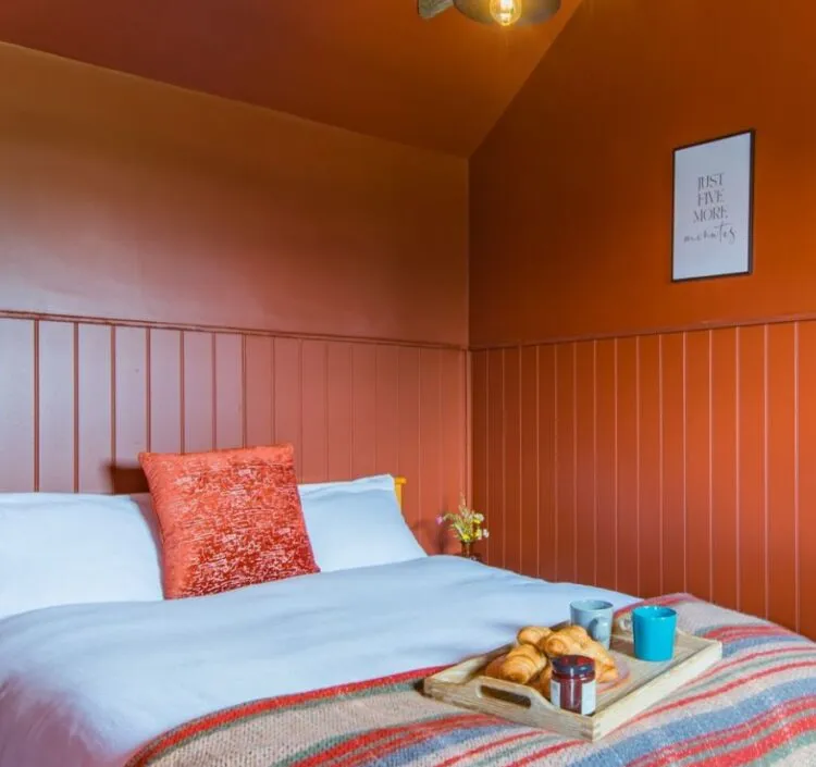 The vibrant terracotta bedroom at Challenger, McCanns Brewery