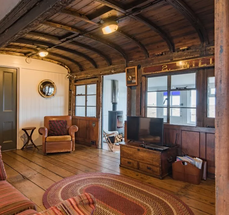 The inside of Sunray, a Dungeness Holiday Home that has an old railway carriage running through the living room.
