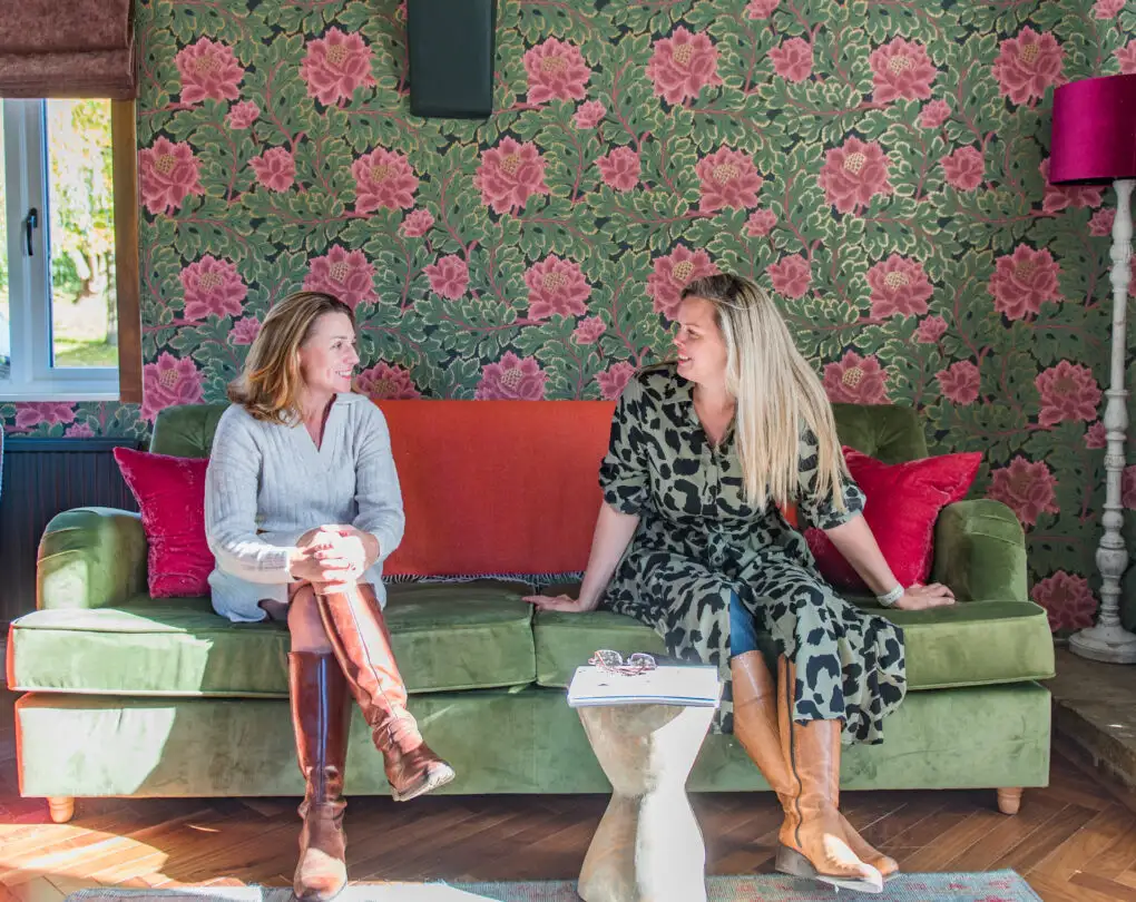 Rowena and Nicky, co founders of Bloom Stays, sat on a sofa Lower Standen Farm, a holiday home in Kent