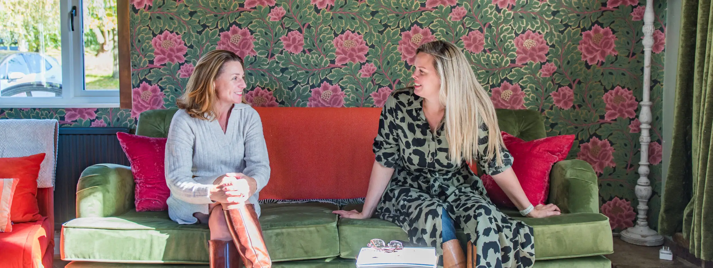 Rowena and Nicky, co founders of Bloom Stays, sat on a sofa Lower Standen Farm, a holiday home in Kent