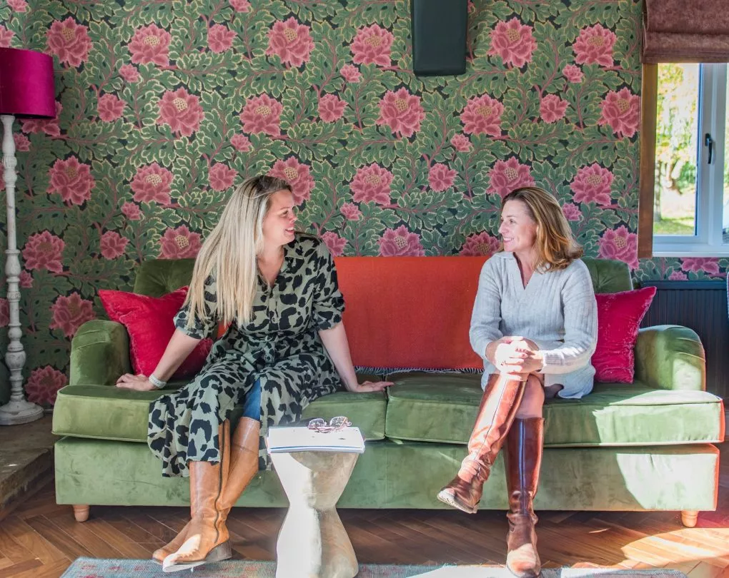 Rowena and Nicky, co founders of Bloom Stays, sat on a sofa Lower Standen Farm, a holiday home in Kent