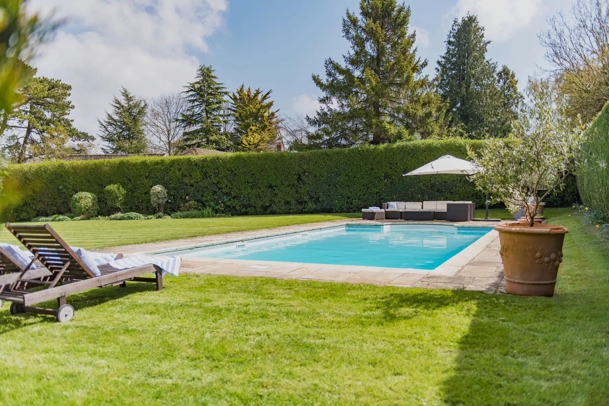 A sunny photo of a swimming pool at Burleigh House, a holiday cottage in Ashford, Kent