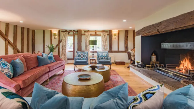 The large living room of Lower Standen Farm, a Holiday Home in Benenden with an open log fire perfect for large groups.
