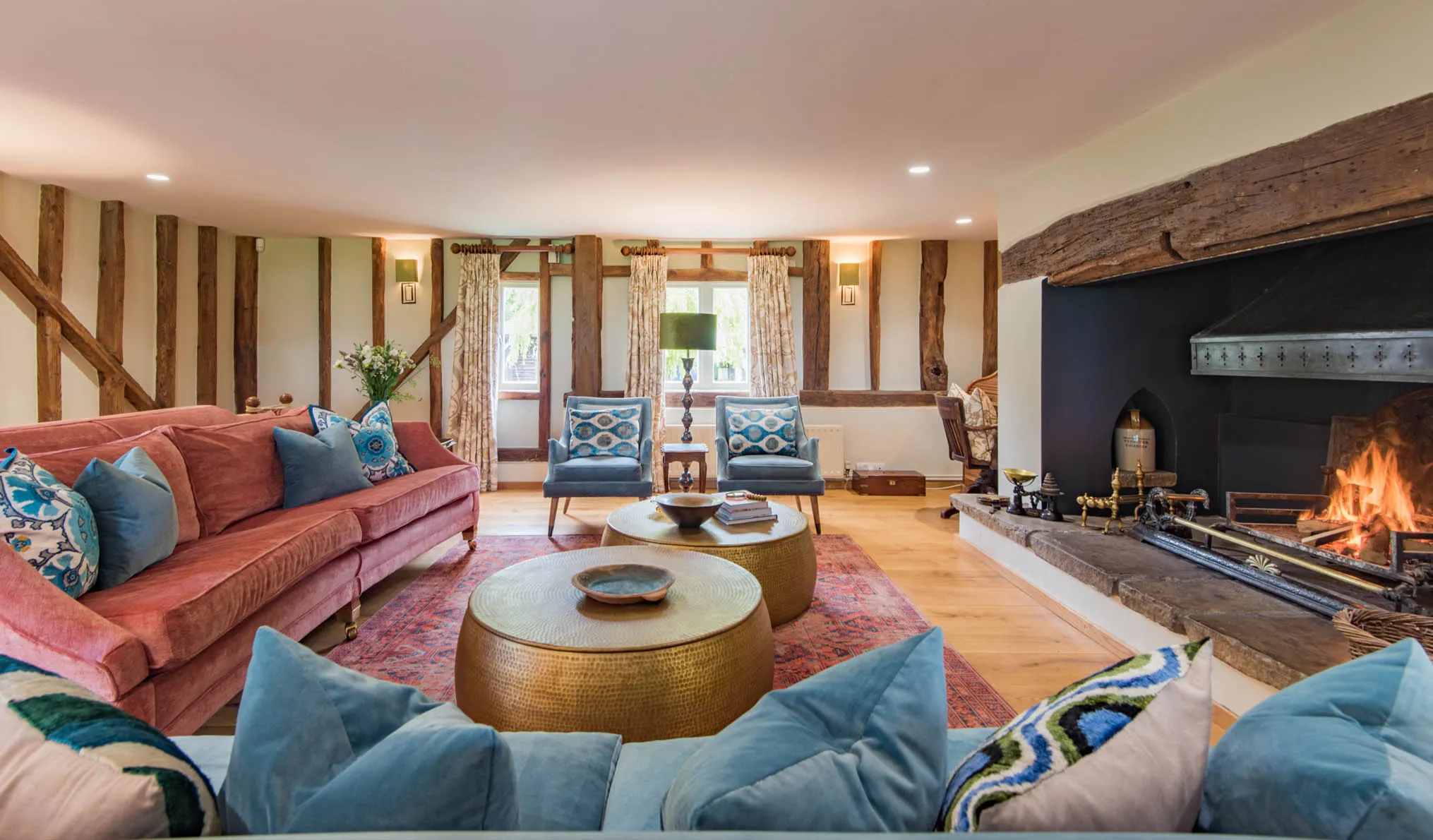 The large living room of Lower Standen Farm, a Holiday Home in Benenden with an open log fire perfect for large groups.