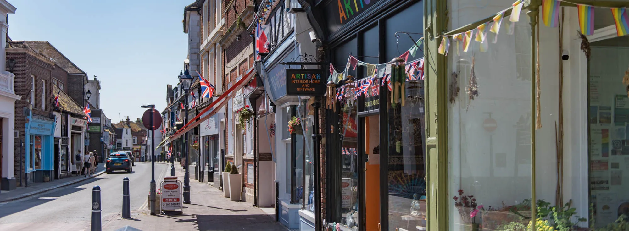 The sunny high street of Hythe in Kent, packed with independent shops and cafes, a popular place for holidays.