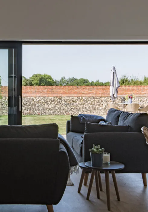 The Bull Pen is a dog friendly holiday home in Ashford, it's a converted farm building. The living room looks out to the brick walled garden and freshly mowed lawn.