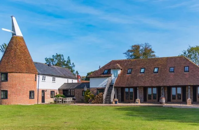 A sunny photo of The Oast in Newenden, with blue skies and cut grass