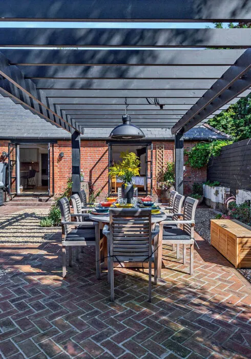 Outdoor courtyard with the table laid up for al fresco lunch under the pergola