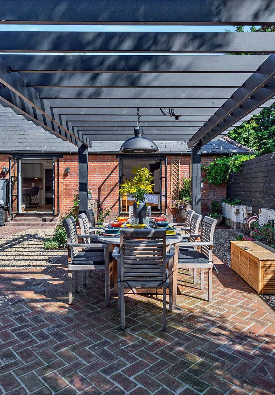 Outdoor courtyard with the table laid up for al fresco lunch under the pergola