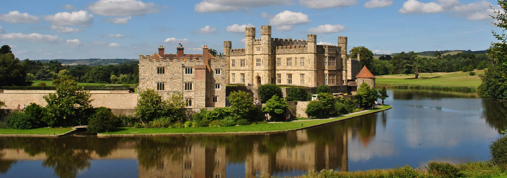 External shot of Leeds Castle in Maidstone, capturing the big mote that surrounds the castle grounds.
