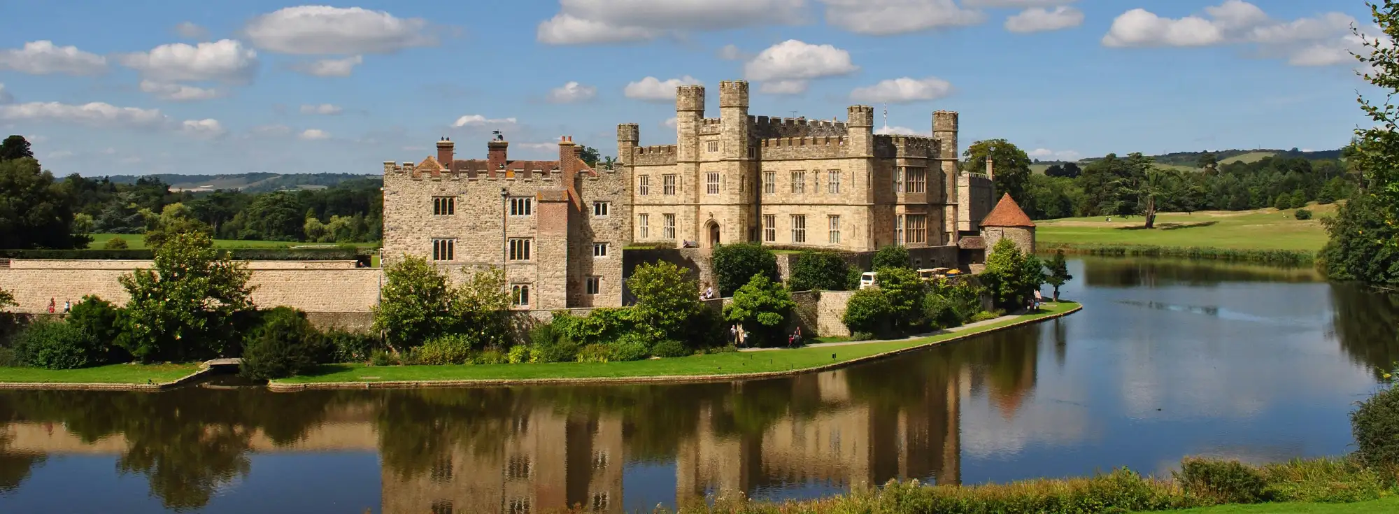 External shot of Leeds Castle in Maidstone, capturing the big mote that surrounds the castle grounds.