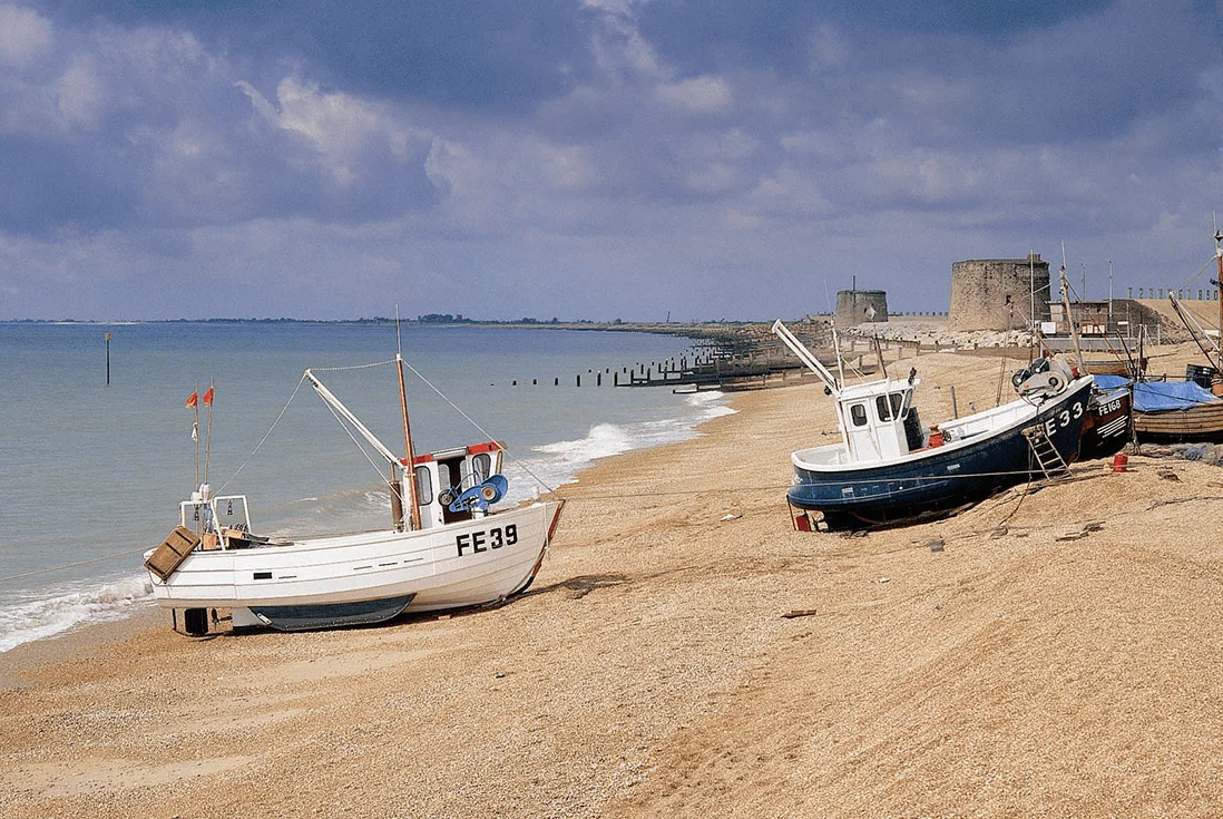 Blue skies and boats parked up on the beach at Dymchurch