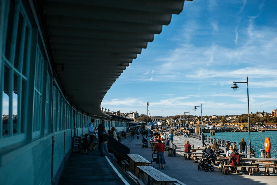 People eating and drinking along the Folkestone Harbour Arm