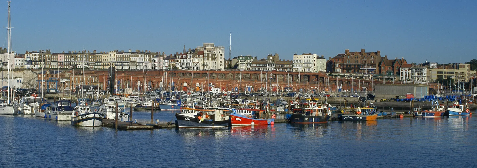 Wide shot of the boats in Ramsgate harbour with blue open skies