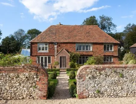 The front of Dormestone House with a brick wall and gravel path leading to the front door