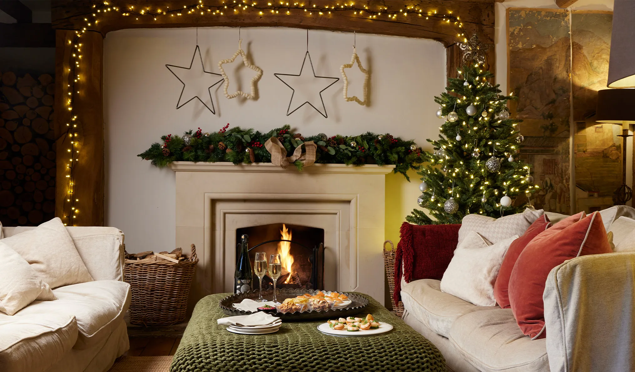 A Christmas cottage with a lit fire and fully decorated Christmas Tree