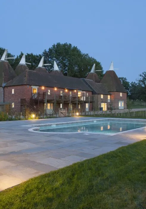 Finchcocks Oast at dusk – exterior view with swimming pool