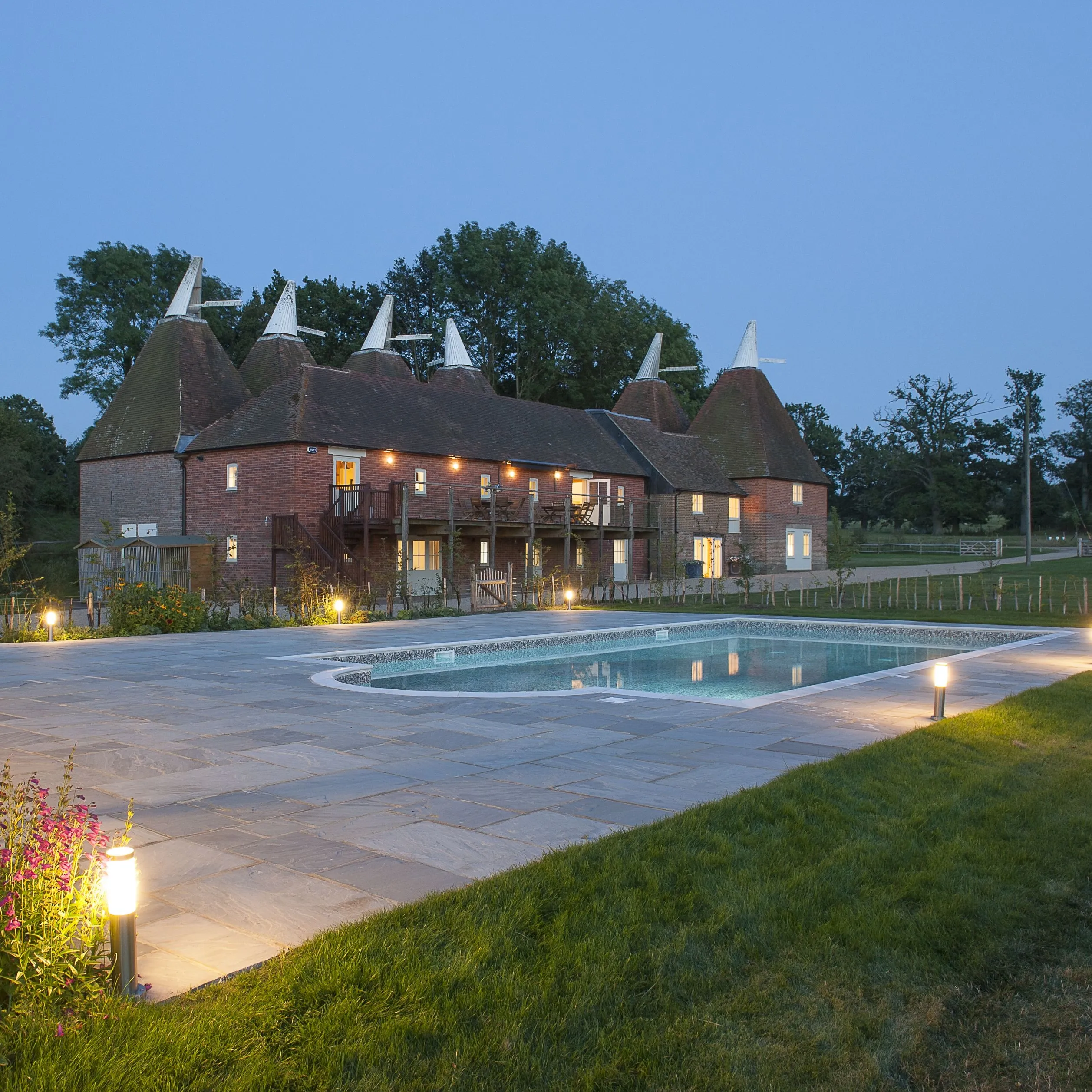 Finchcocks Oast at dusk – exterior view with swimming pool