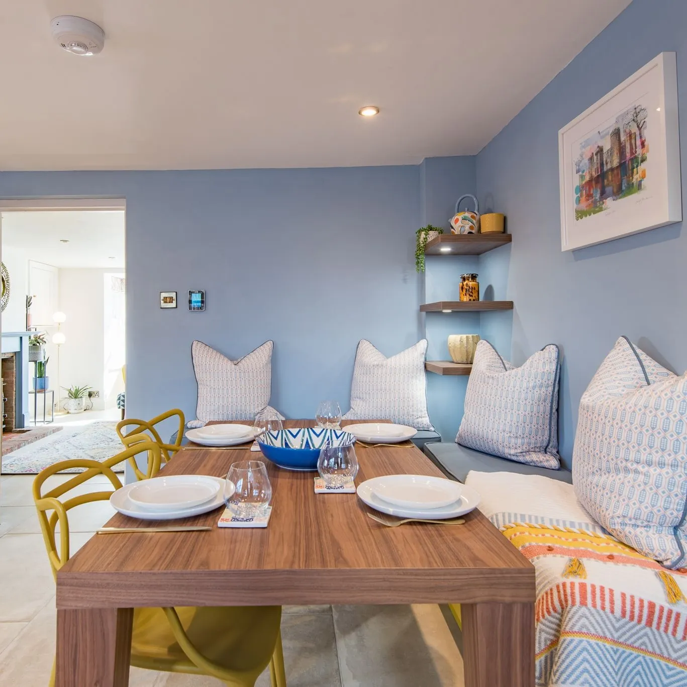 The bright and cosy dining space at Wheelwrights Cottage in Staplecross Nr Rye. The table is laid with plates, glasses and cutlery.