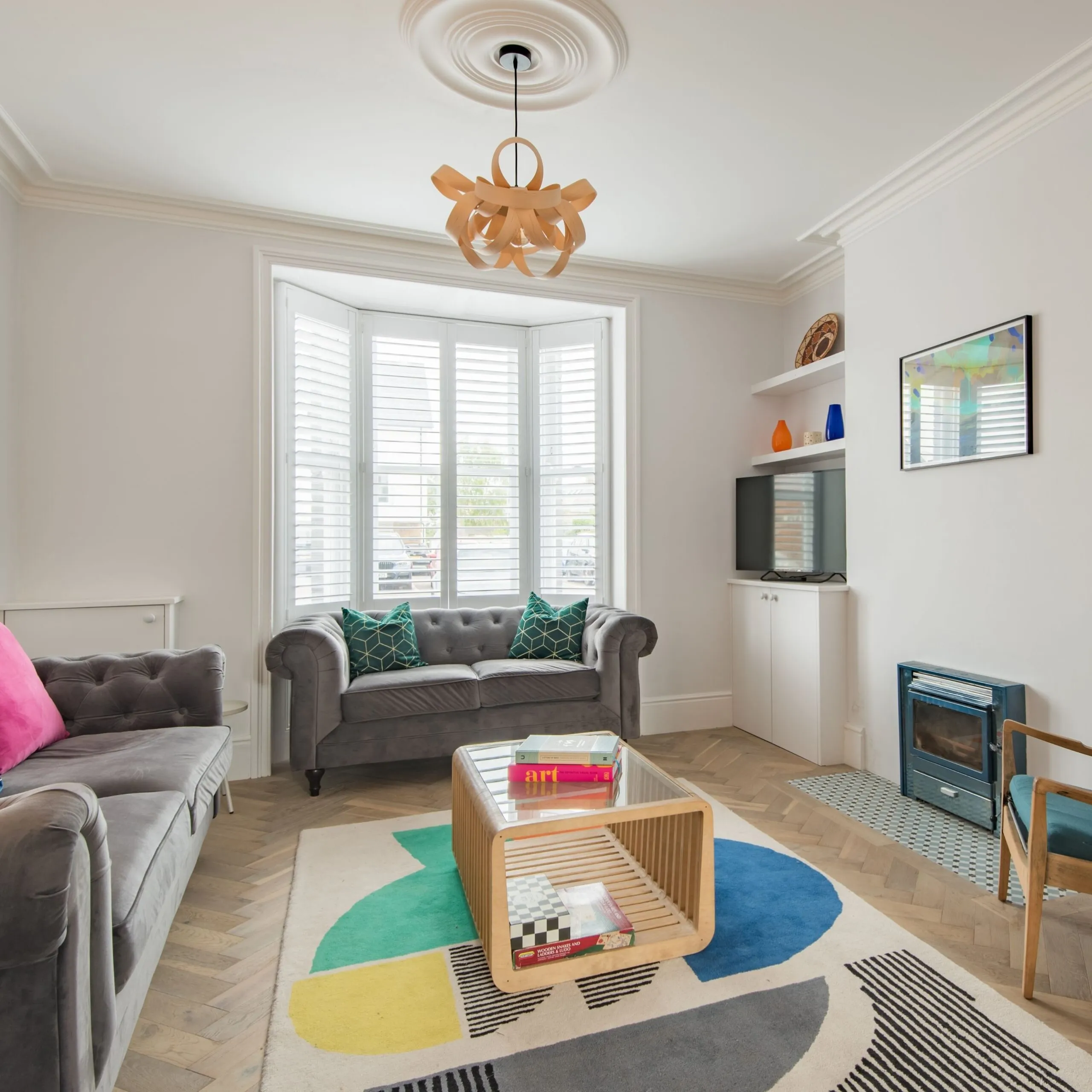 Living room with grey furnishings and colourful rug at Little Oyster, Whitstable