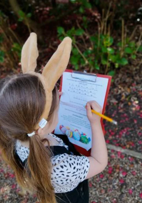 A young girl filling out an Easter quiz at Belmont House