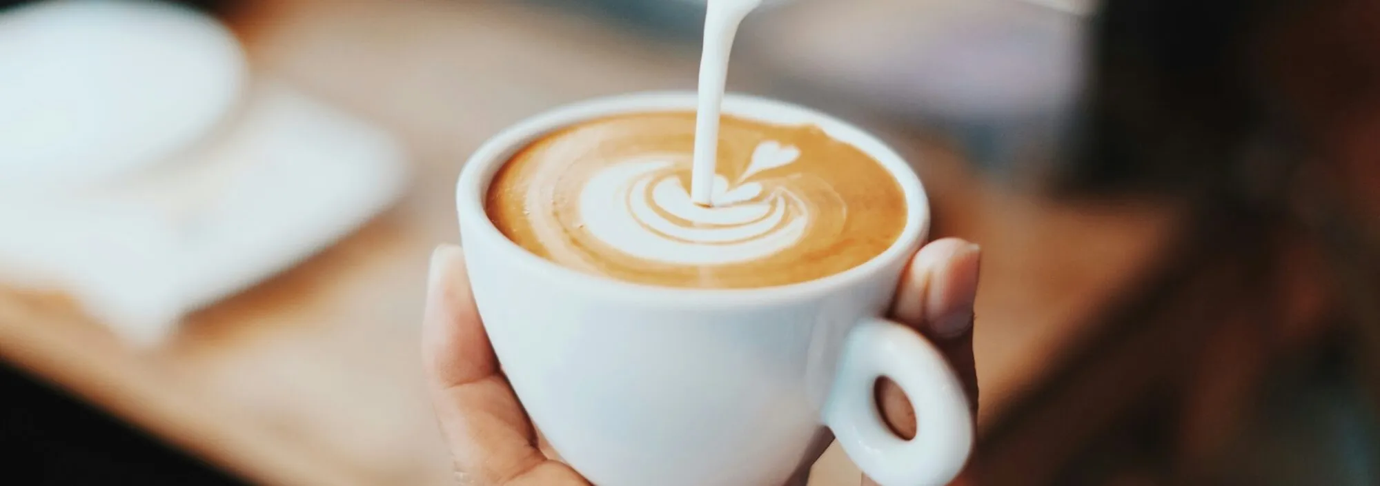 Pouring milk into a fresh coffee | Best cafes in Kent & East Sussex | Fahmi Fakhrudin