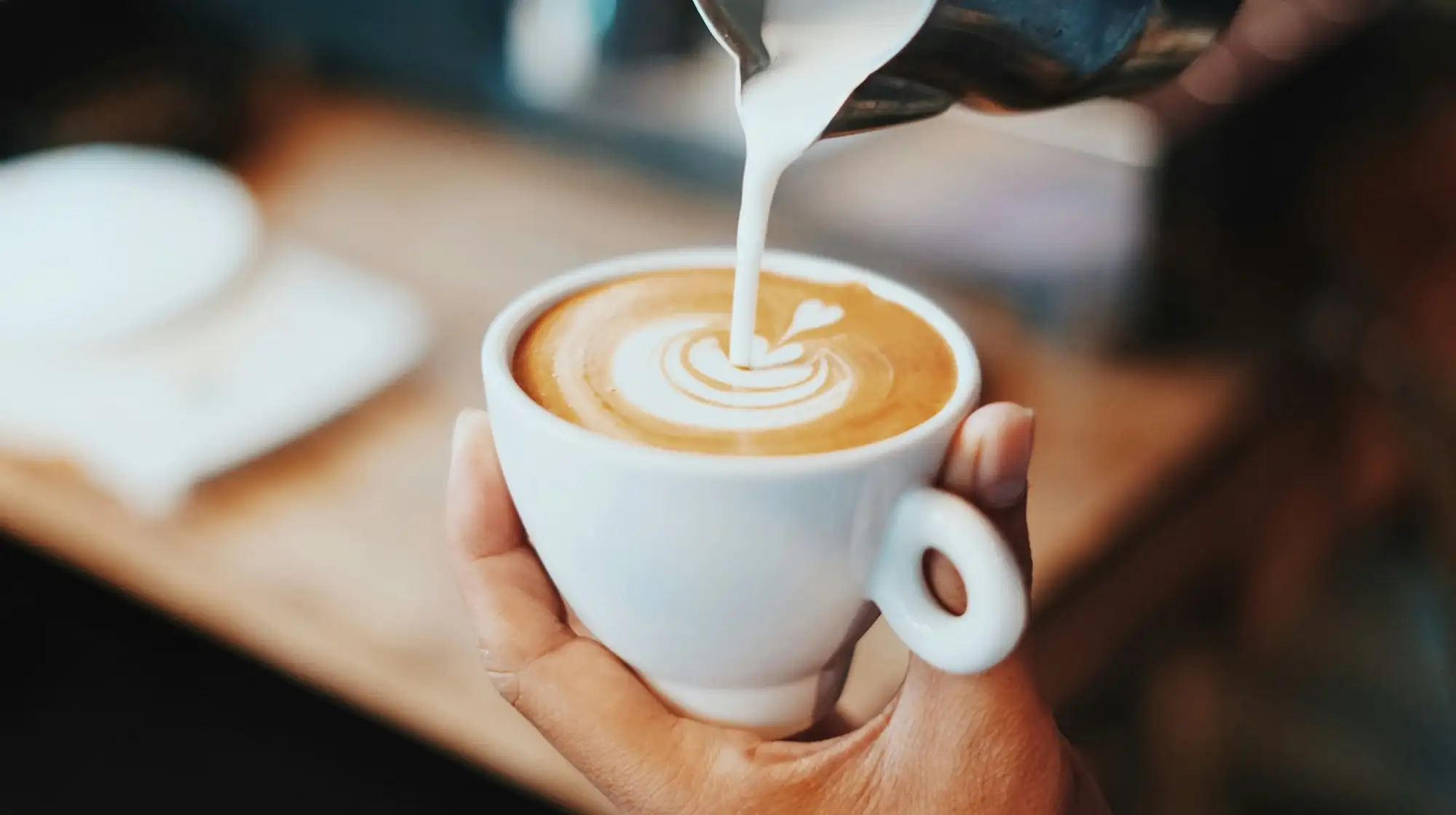 Pouring milk into a fresh coffee | Best cafes in Kent & East Sussex | Fahmi Fakhrudin